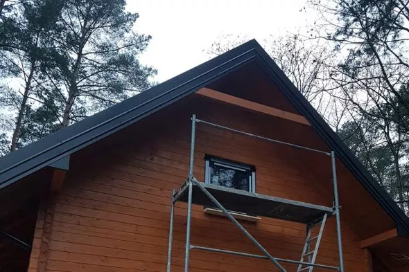 czarne okna pcv w domu z drewna